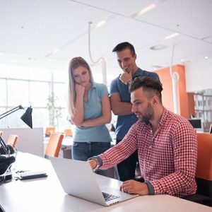 Young Jewish professionals working around a laptop.